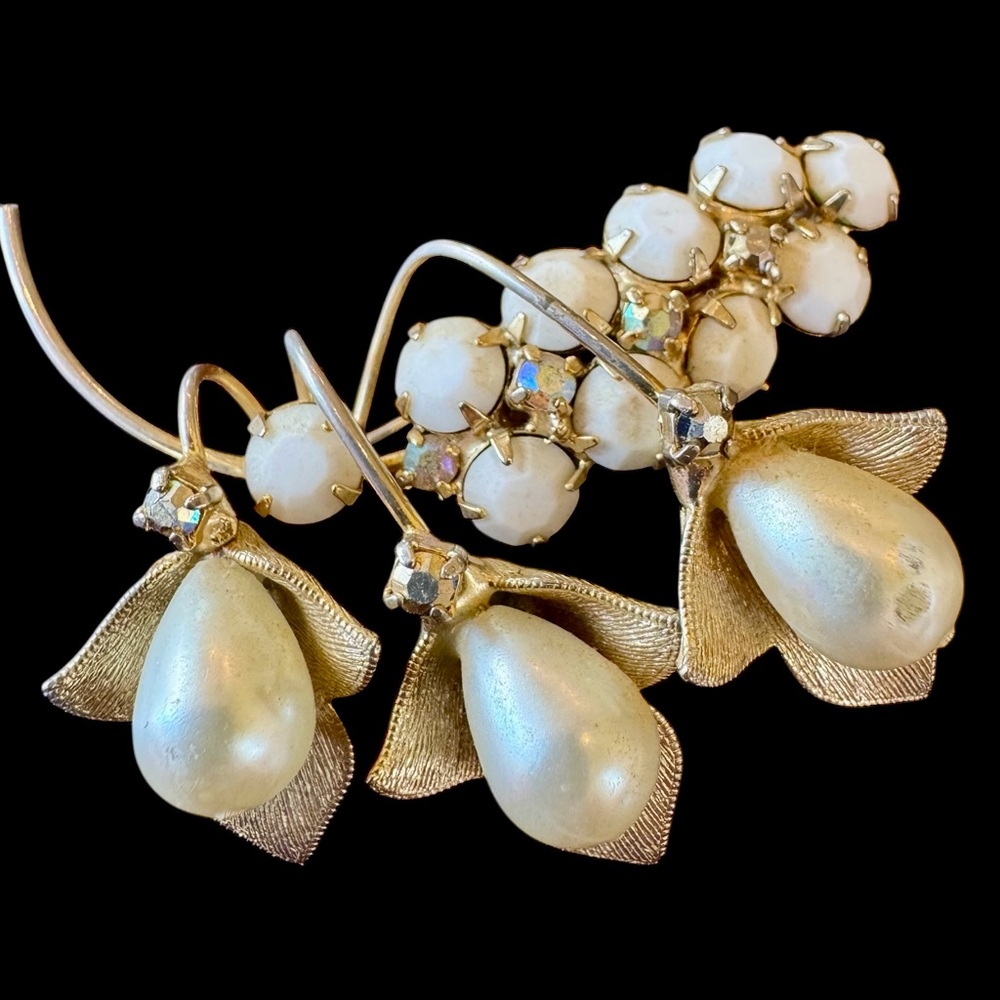 Gold-tone floral brooch with textured petal drops.
